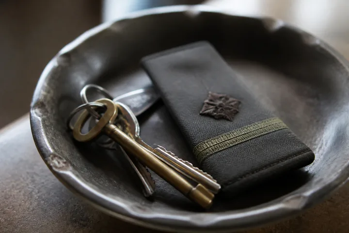 A rank slide and a set of keys lying in a shallow dish on a hall table (AI-generated image)