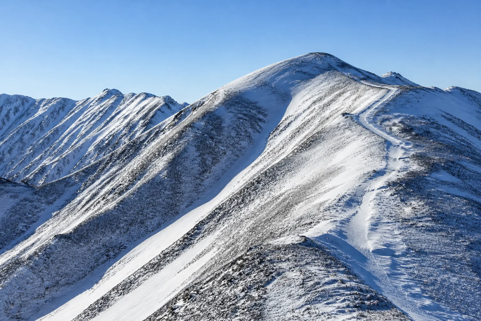 Steep bare ridgelines in winter with snow in the gullies and a frozen track contouring the slope (AI-generated image)